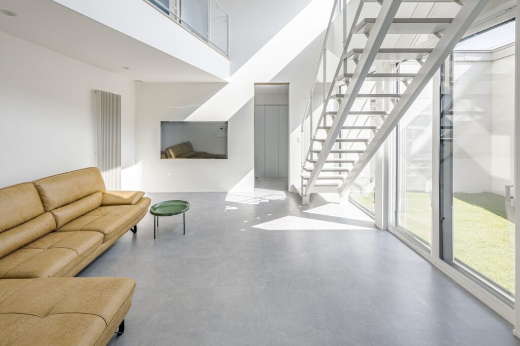 吹き抜けと大開口窓から光が差し込むホワイトリビング