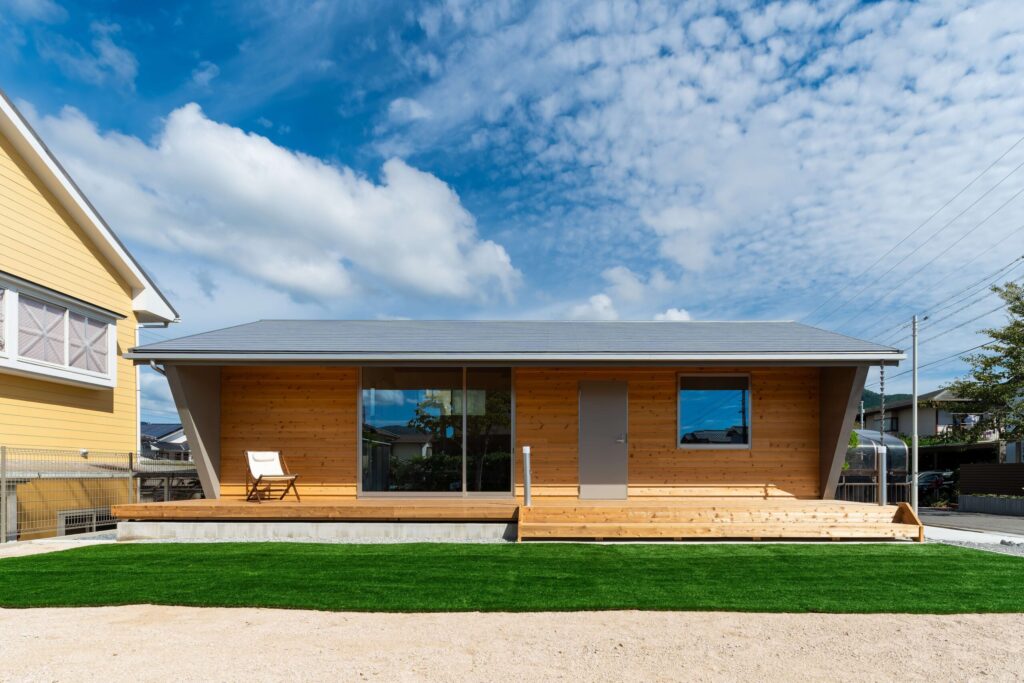 芝生とデッキが広がる平屋の外観