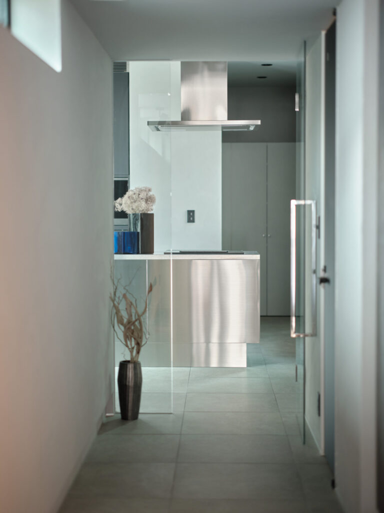 廊下から見えるシルバーのキッチン