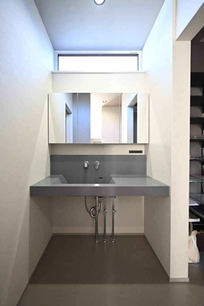 グレーの造作洗面台のあるシンプルな洗面空間