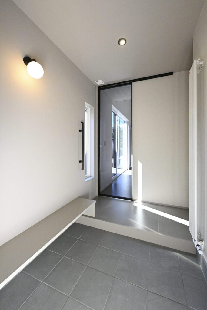 タイル土間とベンチを備えた明るい玄関ホール