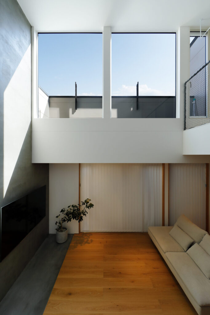 大開口から光が差し込む吹き抜けリビング