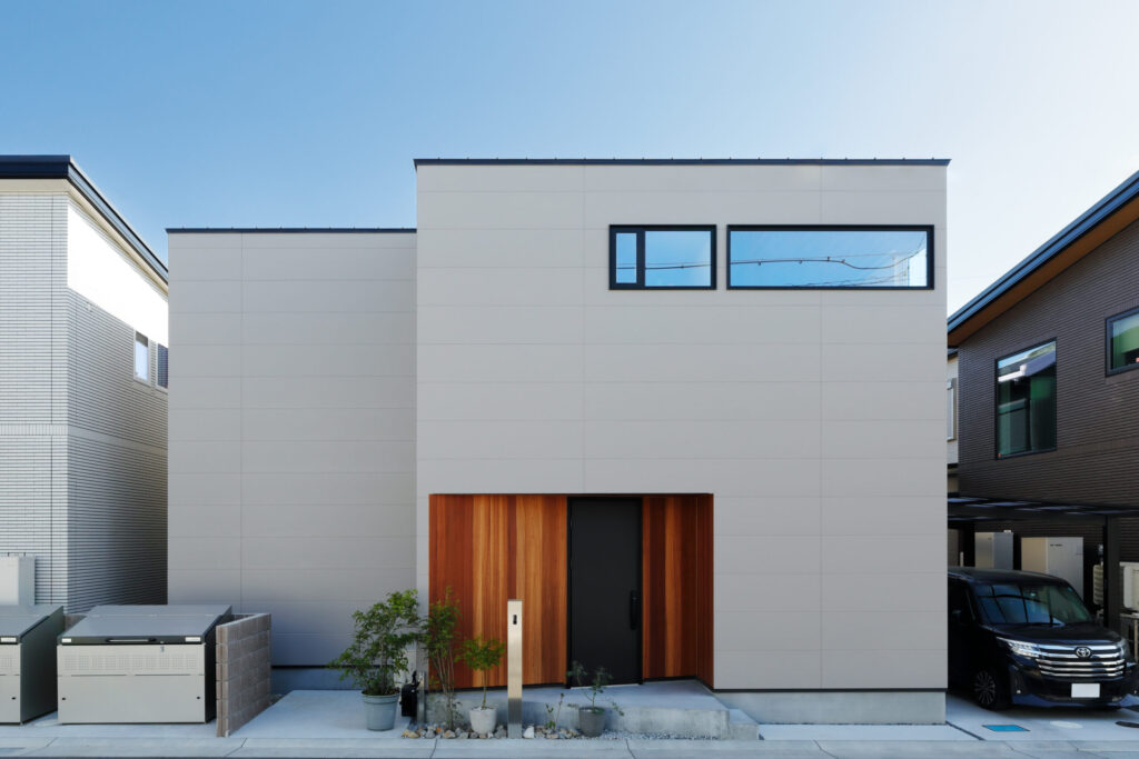 板張り玄関がアクセントのベージュ外観